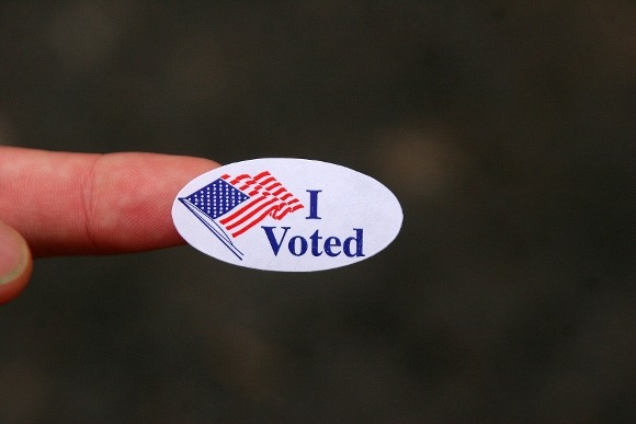 Finger holding an I voted sticker